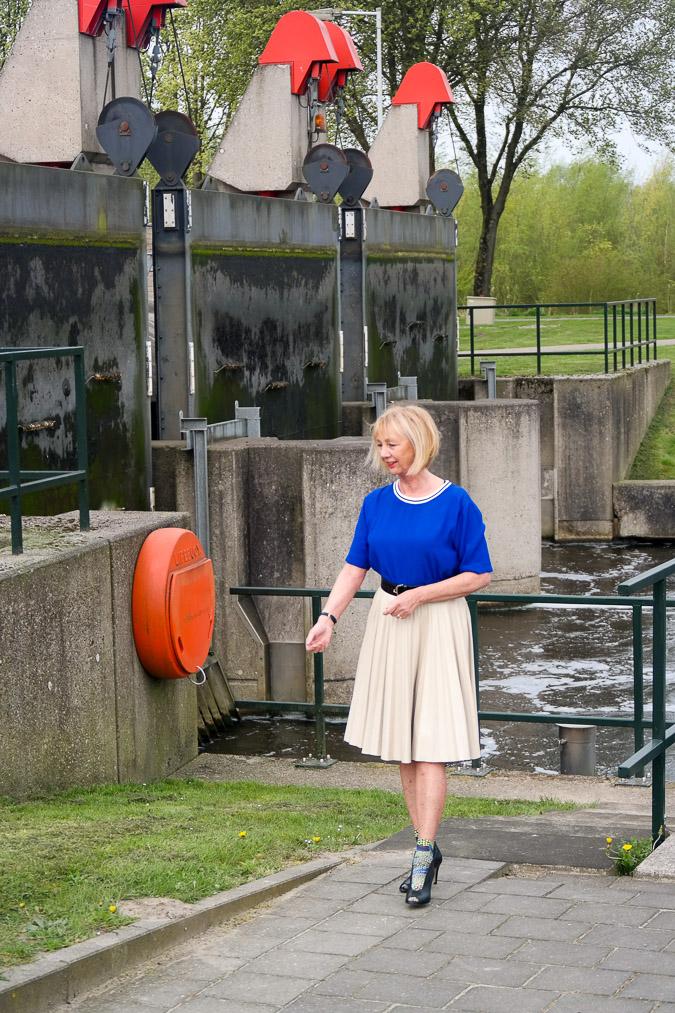 Bright blue top with a camel pleated skirt