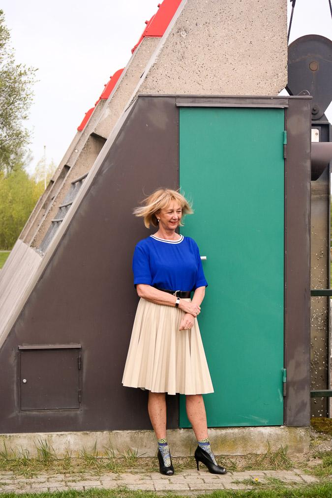 Bright blue top with a camel pleated skirt