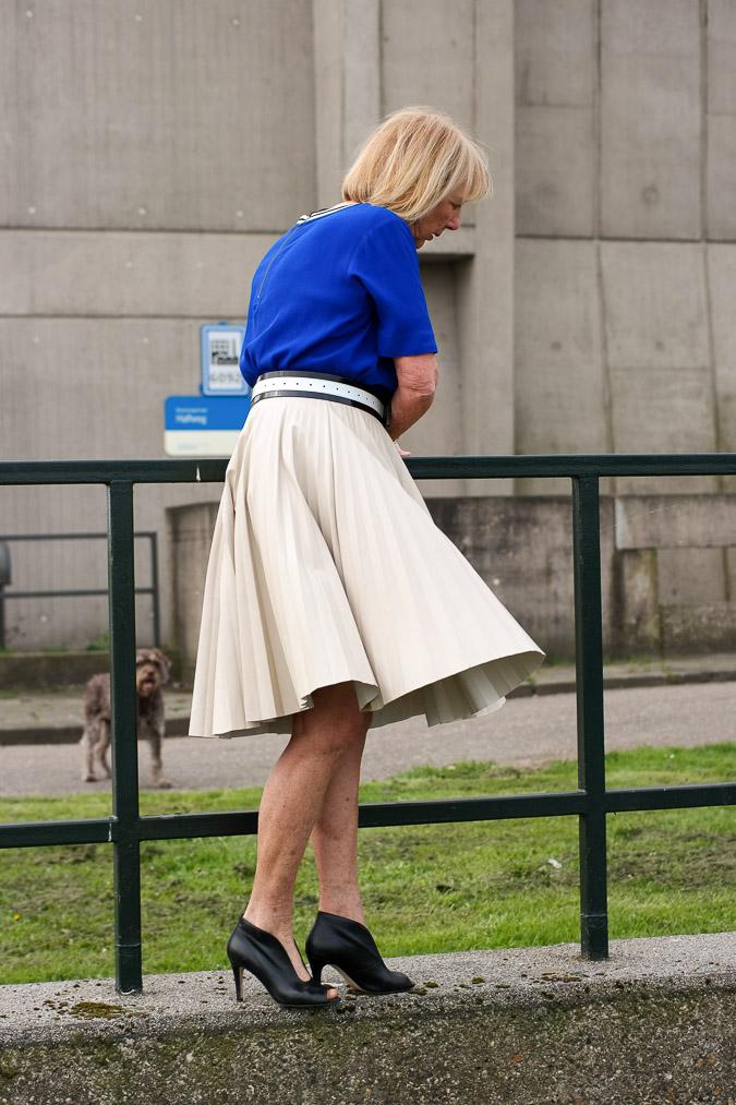 Bright blue top with a camel pleated skirt