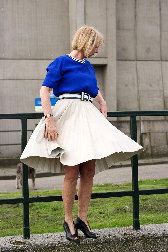 Bright blue top with a camel pleated skirt
