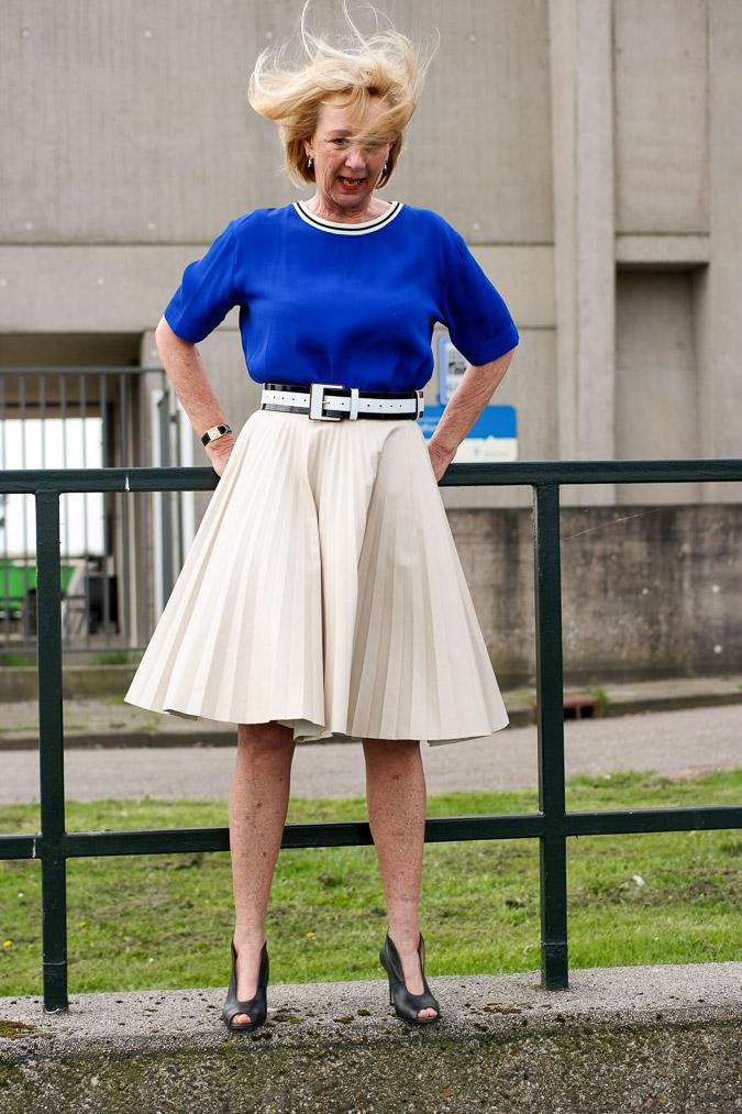 Bright blue top with a camel pleated skirt