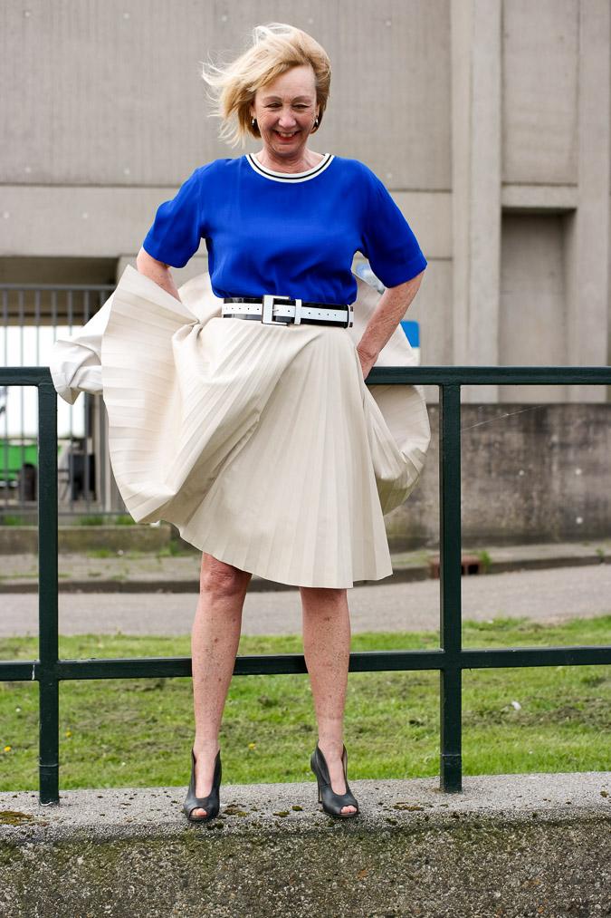 Bright blue top with a camel pleated skirt