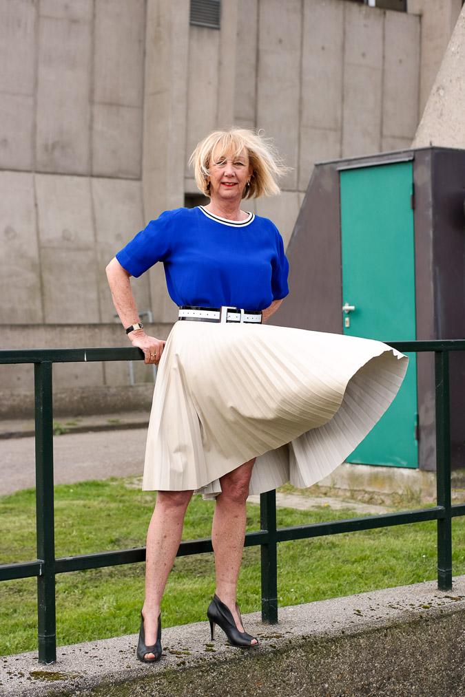 Bright blue top with a camel pleated skirt