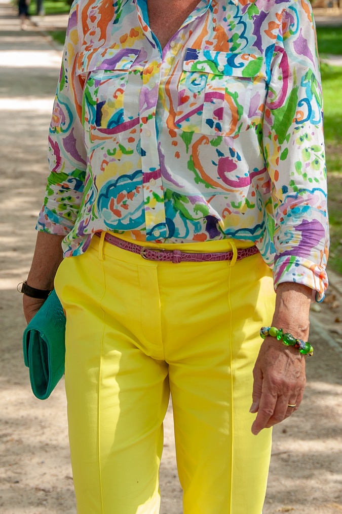 Pink belt, bright blue clutch and green bracelet