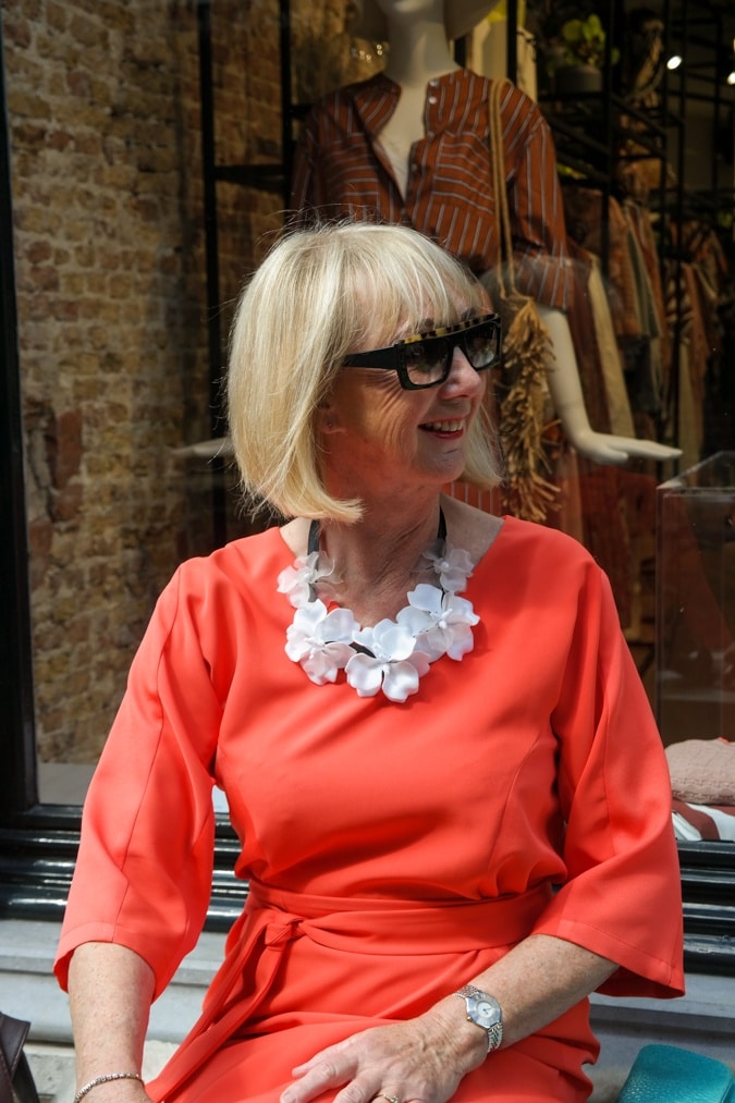 orange dress and a floral necklace